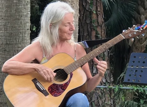 woman playing guitar and singing